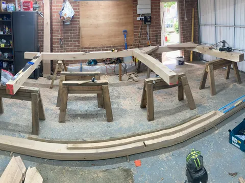 Curved oak beams cut and laid out in the workshop