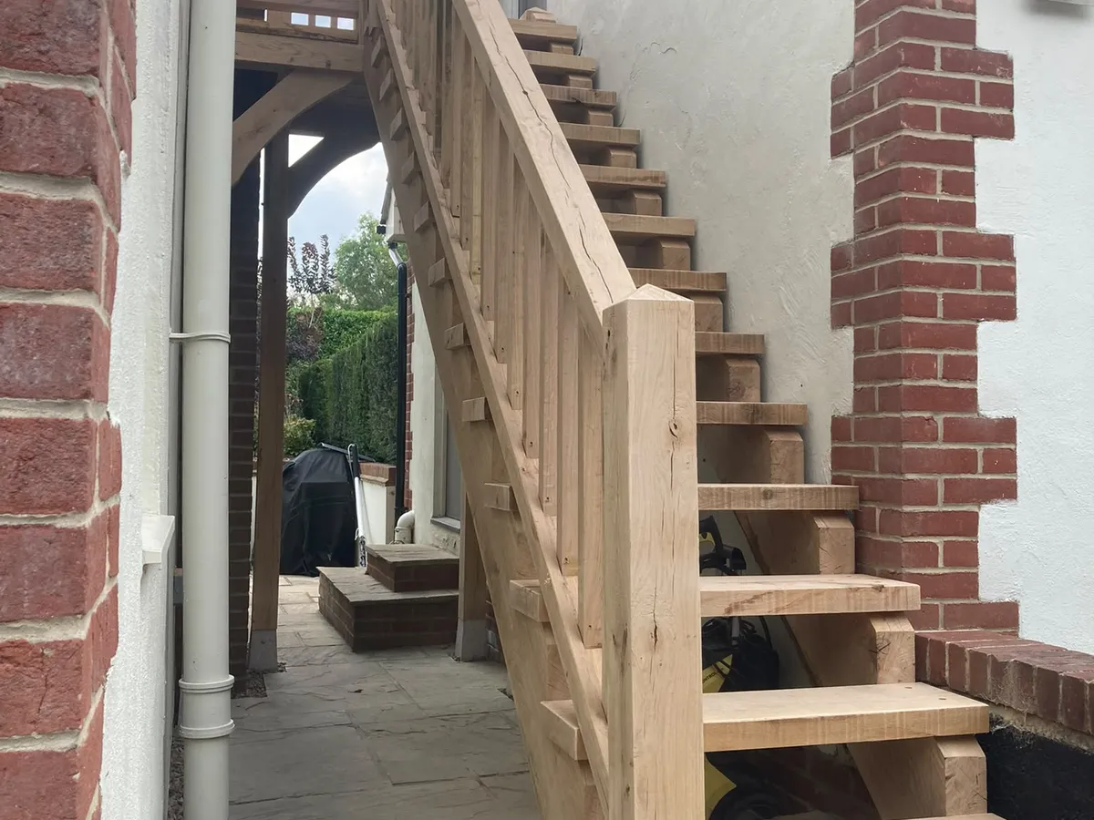 External oak staircase with balustrade between the house and garage