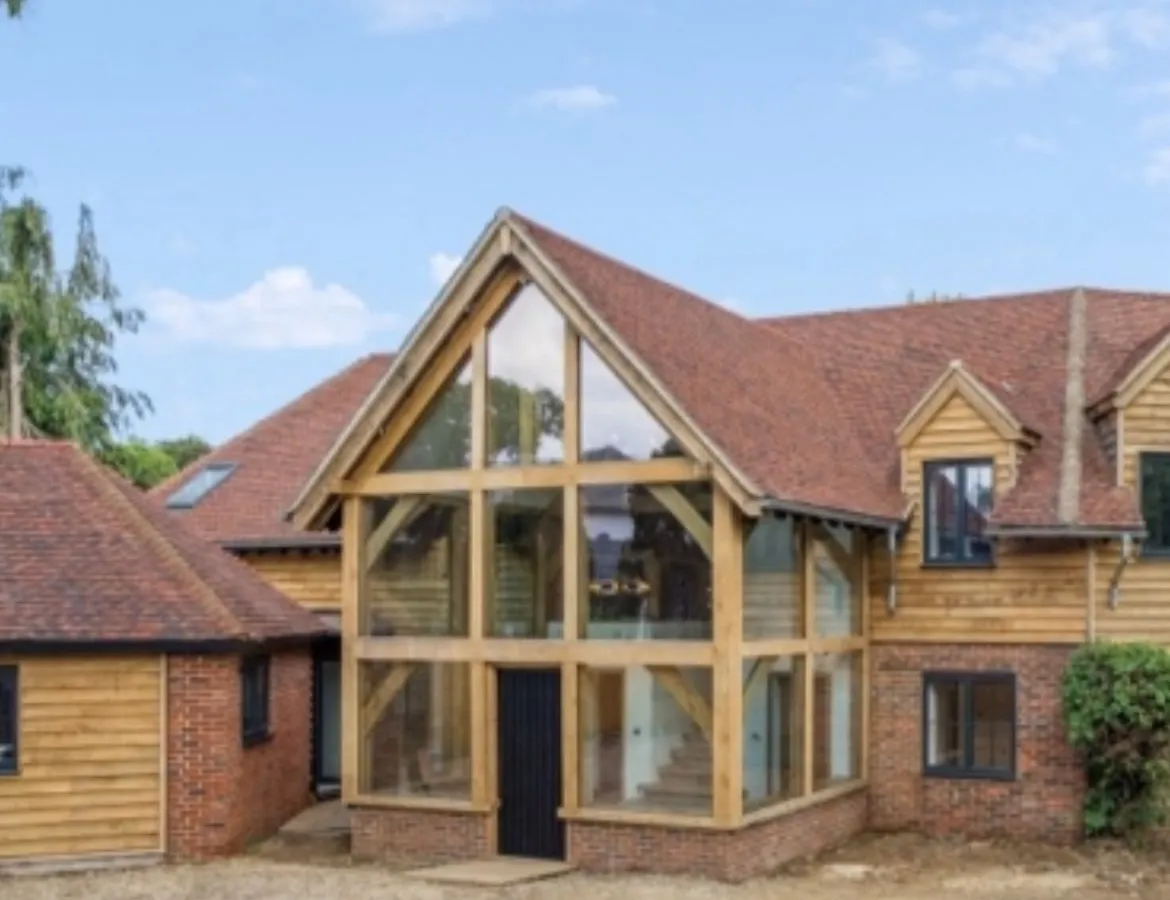 Finished two-storey glazed oak entrance with oak cladding on a brick house