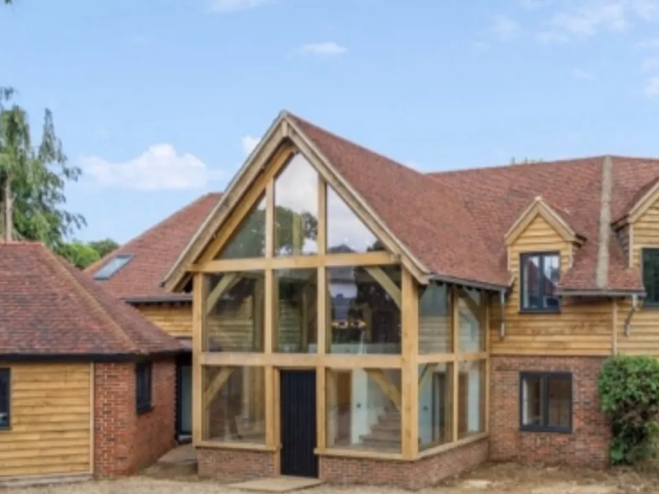Finished two-storey glazed oak entrance with oak cladding on a brick house