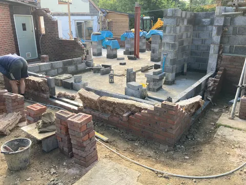 Footings and blockwork going in beside the house with the digger on site