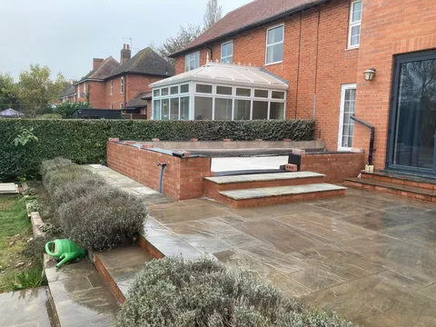 Finished stone terrace and raised beds at the rear of the house
