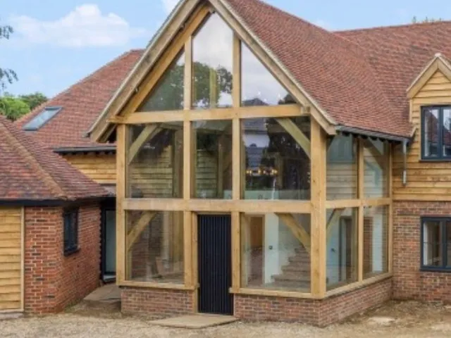 Finished glazed oak entrance with glazing up into the gable on a brick house