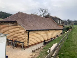 Side elevation of the oak framed garage with waney-edge cladding