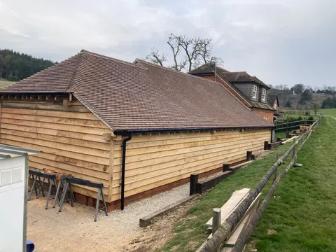 Side elevation of the finished oak framed garage with waney-edge cladding