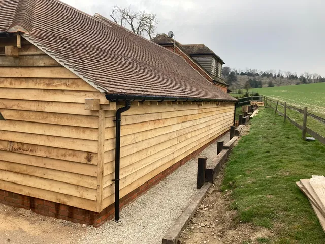 Close view of waney-edge oak cladding on the side of the garage