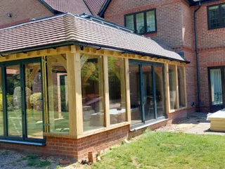Finished oak framed pool room with full-height glazing on three sides