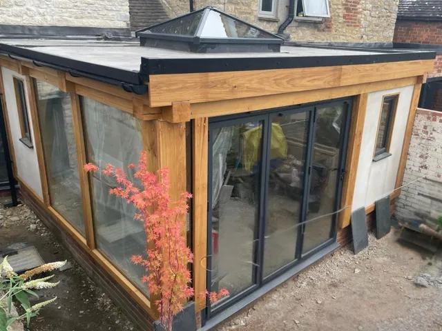 Glazed oak garden room with black-framed doors