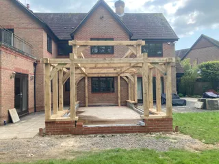 Oak orangery frame raised on a brick plinth against the rear of the house