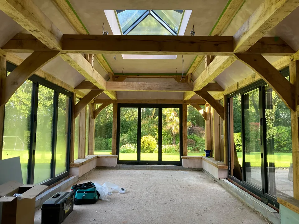 Inside the oak framed pool room: curved braces, roof lantern and glazed doors to the garden