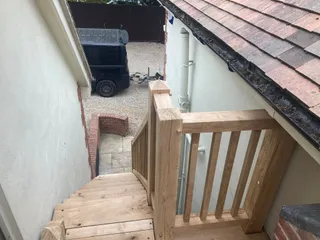 Oak balustrade and newel post detail at the top of the stairs