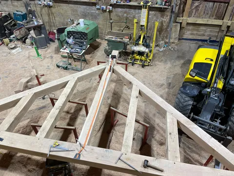 Oak roof truss cut and laid out on trestles in the workshop