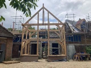 Two-storey oak frame gable raised against the house with scaffolding